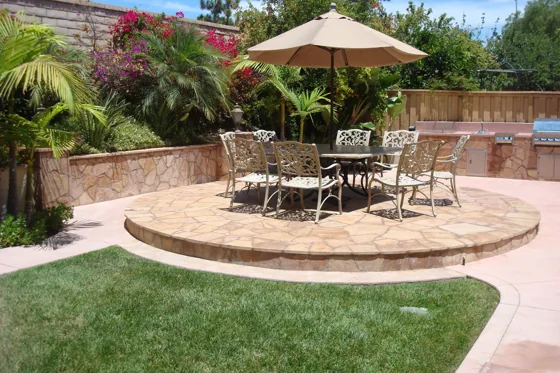 Circular stone patio with outdoor seating and garden