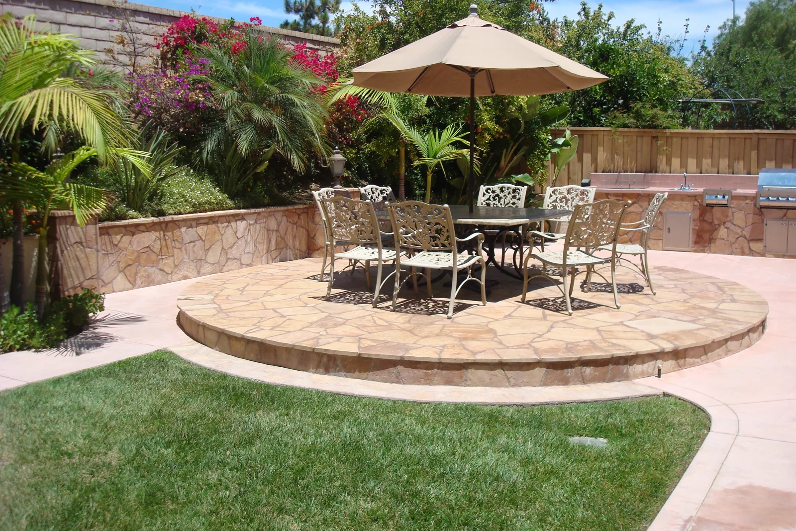 Circular stone patio with outdoor seating and garden